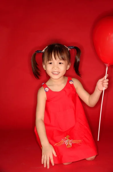 Девочка держит воздушный шар в форме сердца Стоковое Изображение
