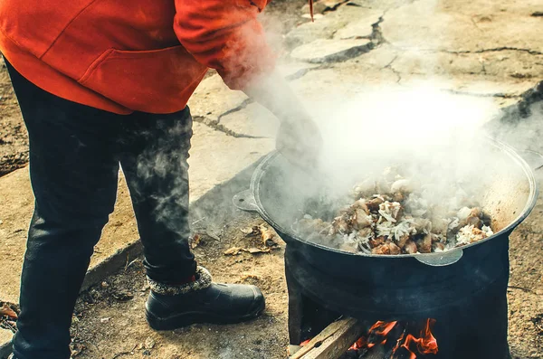 В котле на улице готовят мясо — стоковое фото