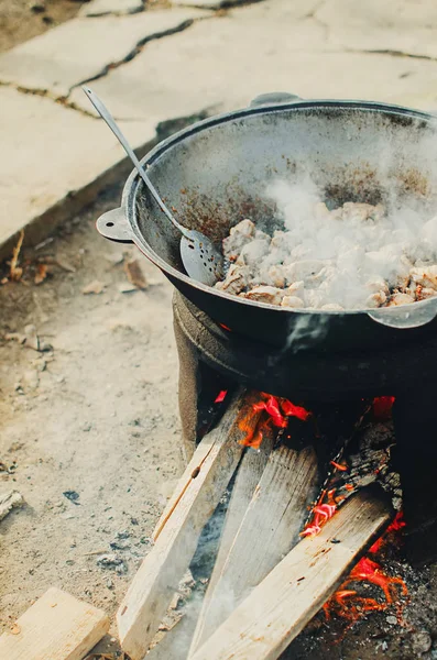 В котле на улице готовят мясо — стоковое фото