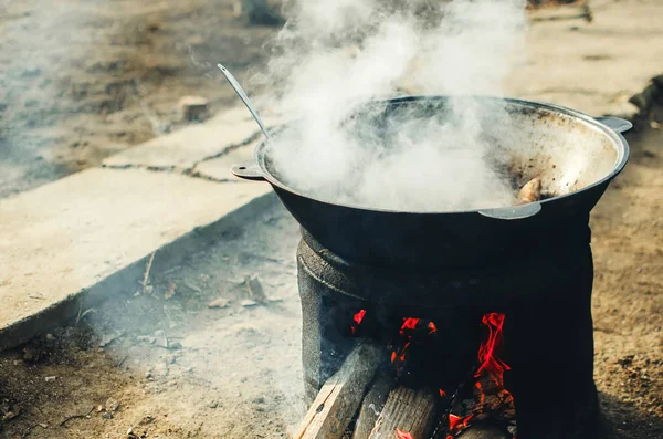 В котле на улице готовят мясо — стоковое фото