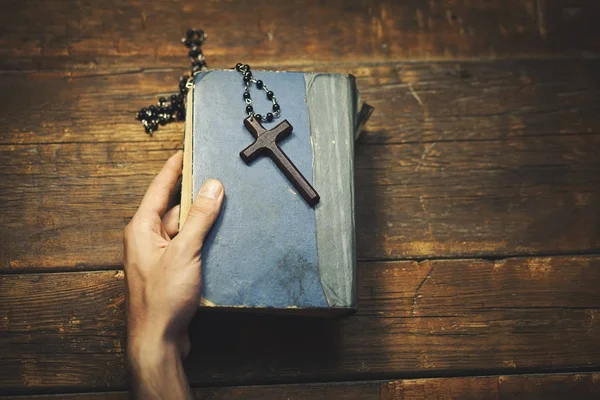 Рука человека крест и Библия — стоковое фото