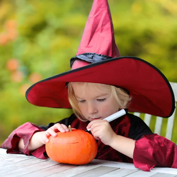 Little girl painting halloween pumpkin Стоковое Изображение