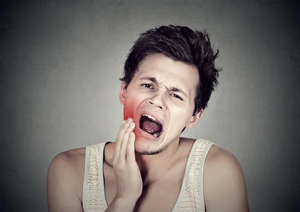 Man with toothache tooth pain outside mouth cheek colored in red — стоковое фото