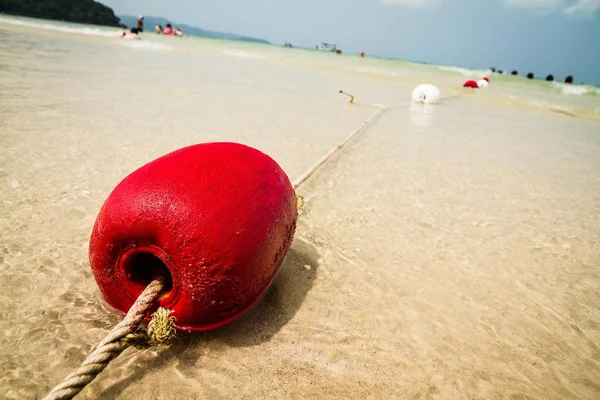 Красный буй на песке — стоковое фото