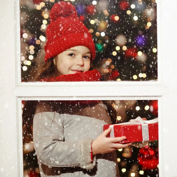 Красивая маленькая девочка улыбается и подарок в Рождество st — стоковое фото
