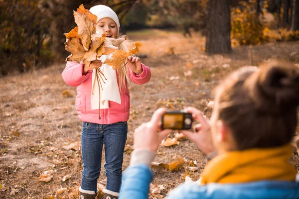 Мать фотографирует дочь в Осеннем парке Лицензионные Стоковые Изображения