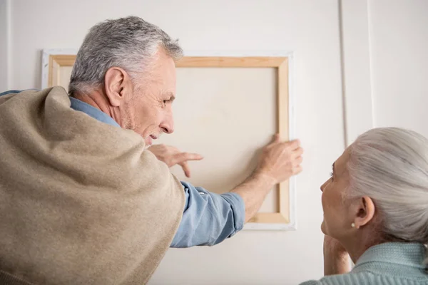 Пожилая пара висит фотография на стене Стоковое Фото