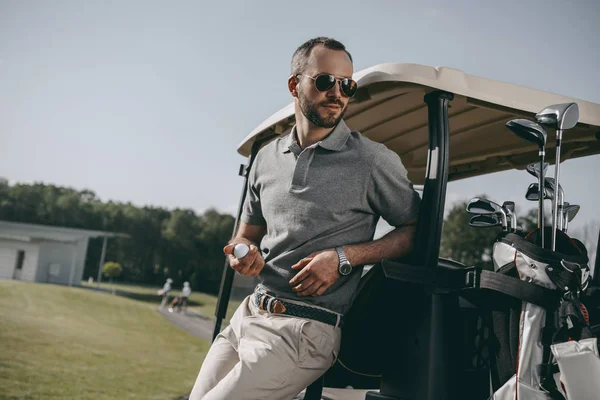 Стильная гольфист, держа мяч для гольфа — стоковое фото