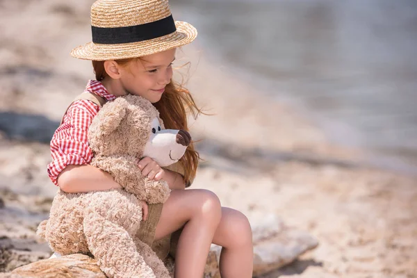 Ребенок с плюшевый медведь на берегу — стоковое фото