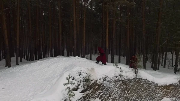 Torchlight procession. Group of monks in hood robe walking along winter snow trail in forest. Footage. Group of monks in hood robe walking along winter snow trail in forest — стоковое фото