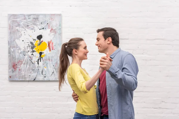 Счастливый Взрослый Пара Танцует Перед Стеной Белого Кирпича Абстрактным Рисунком — стоковое фото