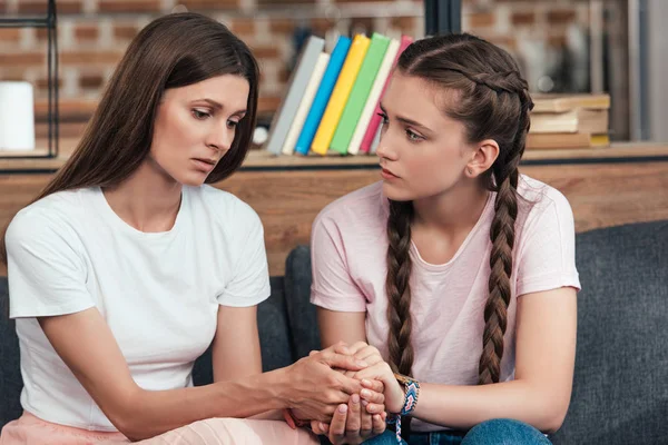 Selective Focus Teenage Girl Holding Hands Frustrated Mother Sofa — стоковое фото