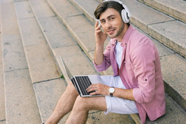 Side View Stylish Man Headphones Laptop Sitting Steps Street — стоковое фото