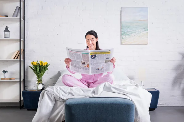 Улыбающиеся Женщина Пижаме Читая Газету Постели Себя Дома — стоковое фото