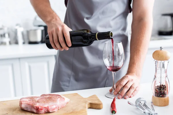 Cropped Shot Man Apron Pouring Red Wine While Cooking Steak — стоковое фото