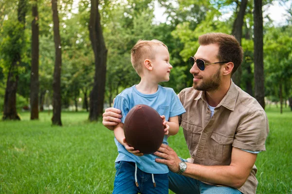 Счастливый Отец Сын Глядя Друг Друга Проведение Американский Футбольный Мяч — стоковое фото