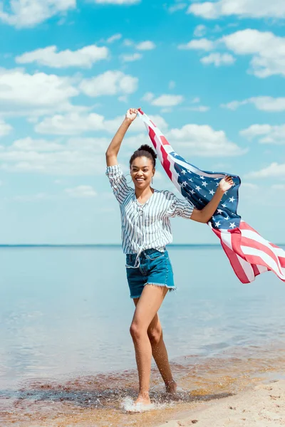 Smiling African American Woman Running Sea Water American Flag Independence — стоковое фото