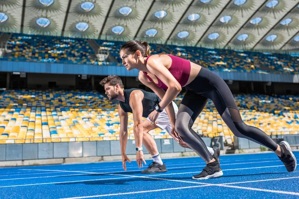 Athletic Young Male Female Sprinters Start Position Running Track Sports — стоковое фото