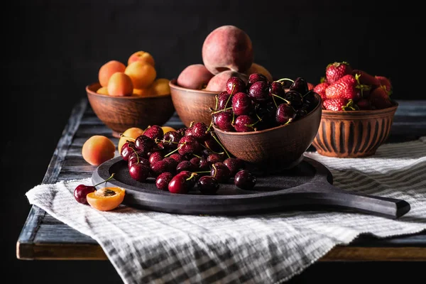 Selective Focus Bowls Cherries Strawberries Peaches Apricots Wooden Table Black — стоковое фото