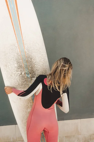 Back View Woman Wetsuit Surfing Board Grey Wall — стоковое фото