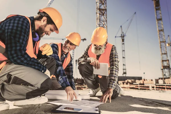 Construction Workers Sitting Concrete Construction Site Looking Building Plans — стоковое фото