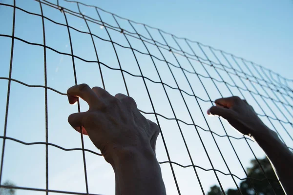 Closeup Hands Man Trying Climb Metal Fence — стоковое фото