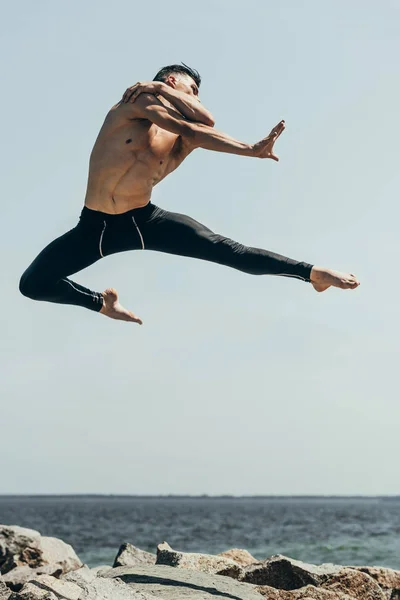Handsome Shirtless Dancer Jumping Rocky Seashore — стоковое фото