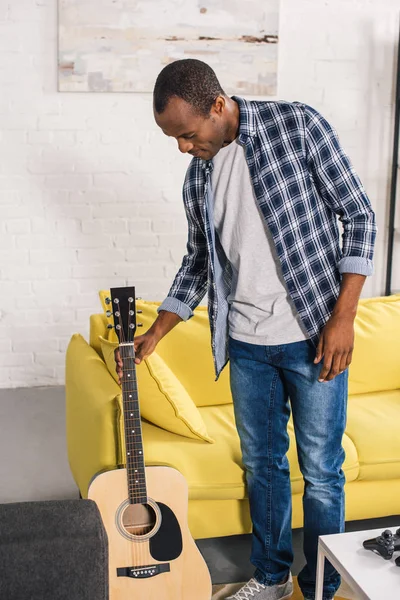 Young African American Man Holding Acoustic Guitar Home — стоковое фото