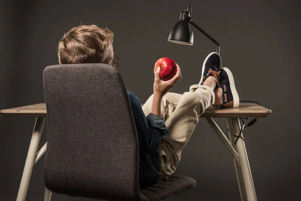 Вид Сзади Маленький Мальчик Отдыхает Ноги Стол Проведение Apple Сером — стоковое фото