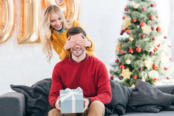 Girl Closing Eyes Making Surprise Gift Box Boyfriend Home Christmas — стоковое фото