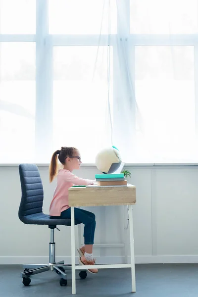 Side View Little Schoolgirl Studying Books Laptop Home Лицензионные Стоковые Изображения