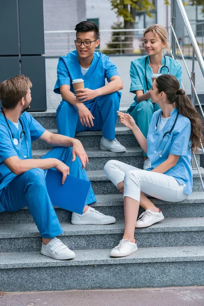 Smiling Multicultural Medical Students Talking While Sitting Stairs — стоковое фото