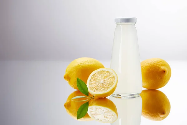 Стеклянная Бутылка Вкусного Лимонада Лимонов Отражающей Поверхности Сером Стоковое Фото