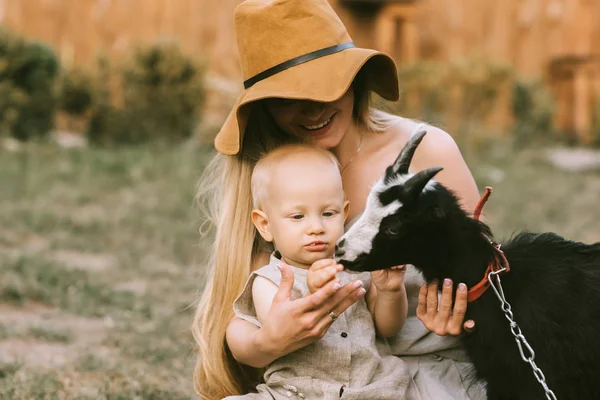 Portrait Smiling Mother Hat Little Son Petting Domestic Goat Countryside — стоковое фото