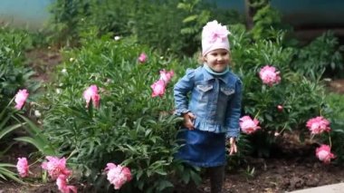 Child girl poses for a photo as a model and dances in the peony garden. — стоковое видео