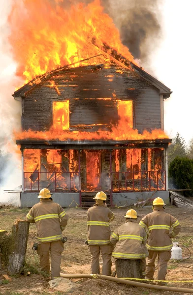 Пожарные на горящий дом Стоковое Фото