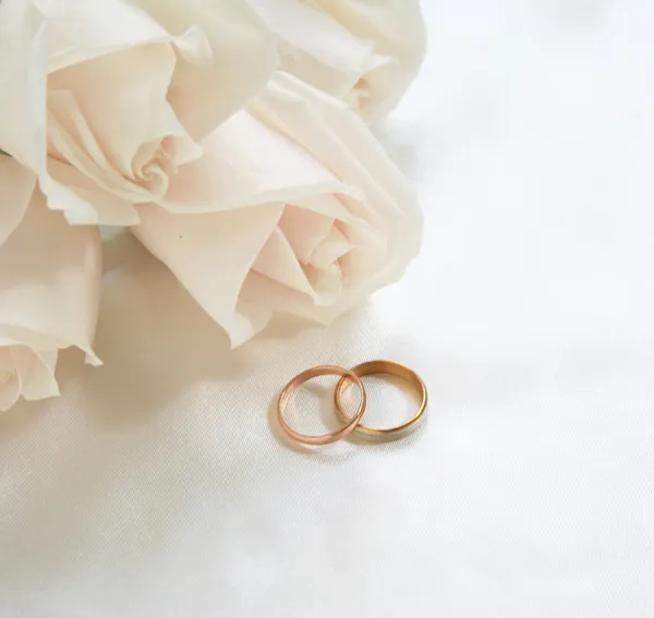 Обручальные кольца и розы как фон Лицензионные Стоковые Фото