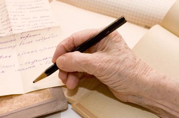 Старые руки пишет письмо карандашом — стоковое фото