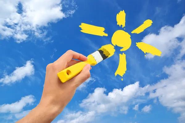 Руки нарисовать Солнце в небе — стоковое фото