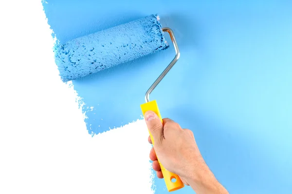 Синяя стена живописи цвета с роликом — стоковое фото