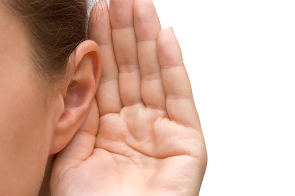 Девочка, слушающая с ее рукой на ухе — стоковое фото