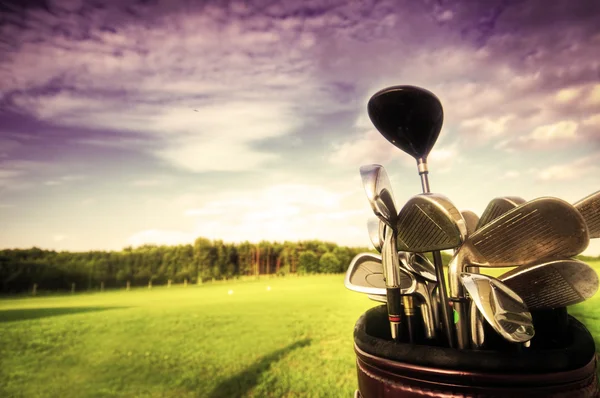 Снаряжение для гольфа, клубы на закате — стоковое фото