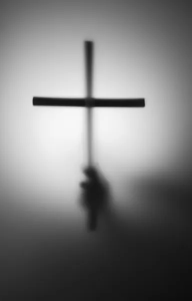Силуэт руки с крестом — стоковое фото