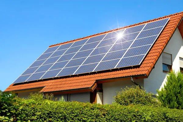 Панели солнечных батарей на красной крышей — стоковое фото