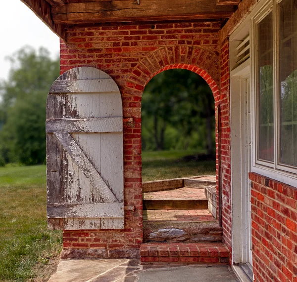 Открытые деревянные двери в кирпичной стеной сад — стоковое фото