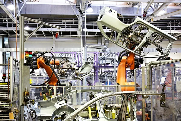 Роботизированные руки в автомобильном заводе — стоковое фото