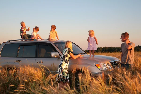 Родители и дети на автомобиле-внедорожнике на пшеничной области — стоковое фото