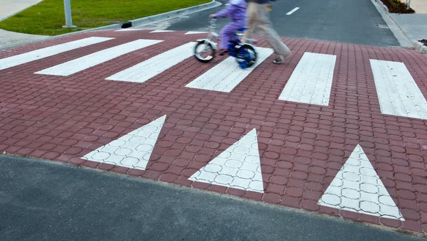 Отец с маленькой девочкой на велосипеде, пересекая улицу (движение bl — стоковое фото