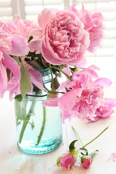 Розовые пионы в стеклянной фляге — стоковое фото