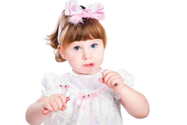 Маленькая девочка живопись помада макияж, изолированные на белом фоне Стоковое Изображение
